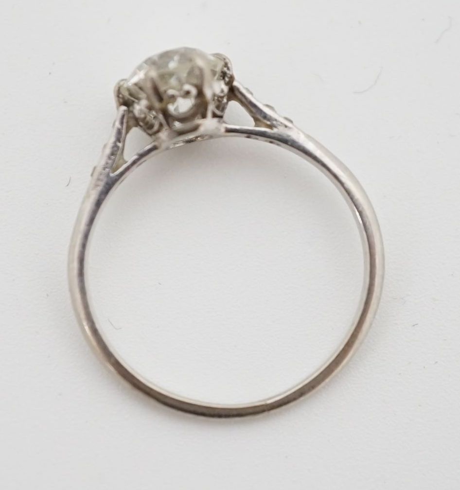 A platinum and single stone diamond ring, with diamond chip set shoulders